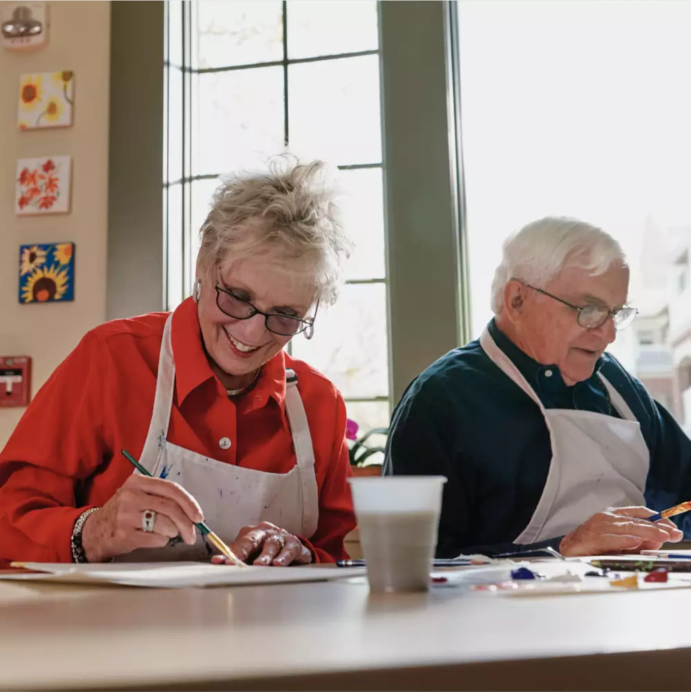 a man and woman smiling and holding a cup of coffee
